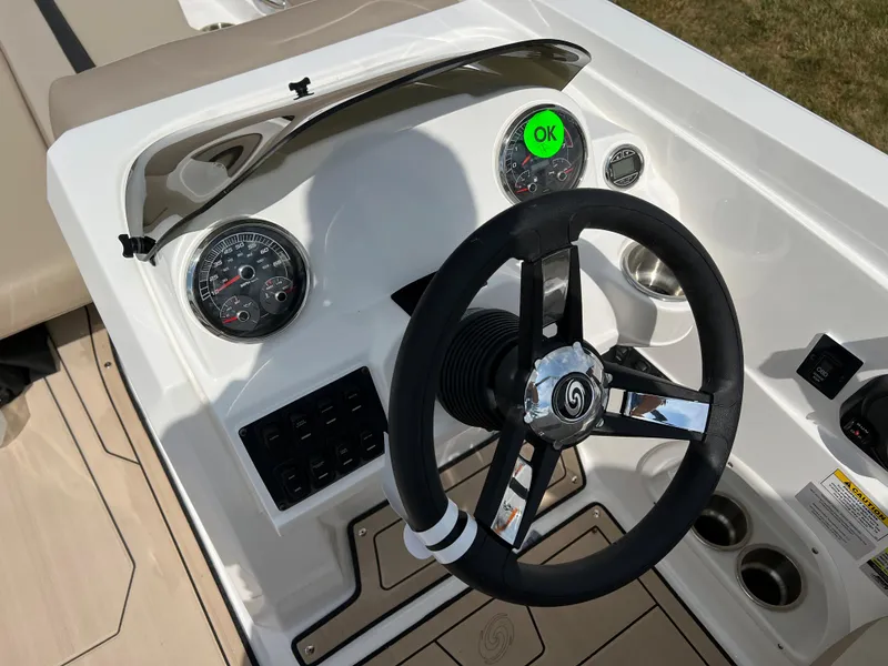 Slide: The Image of 2024 Hurricane SunDeck Sport 205 IO boat dashboard with steering wheel and gauges. - 22