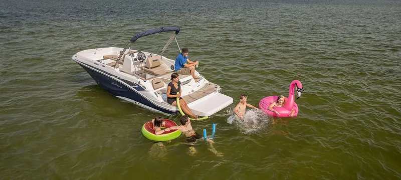 Slide: The Image of 2024 Hurricane SunDeck Sport 205 IO boat with people enjoying water activities. - 26