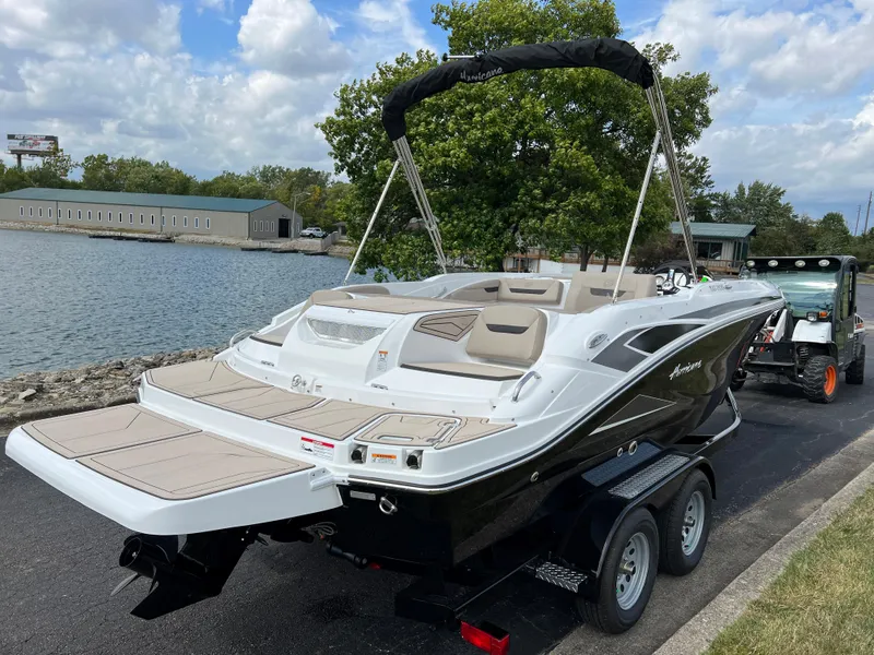 Slide: The Image of 2024 Hurricane SunDeck Sport 205 IO boat on trailer by a lake. - 3