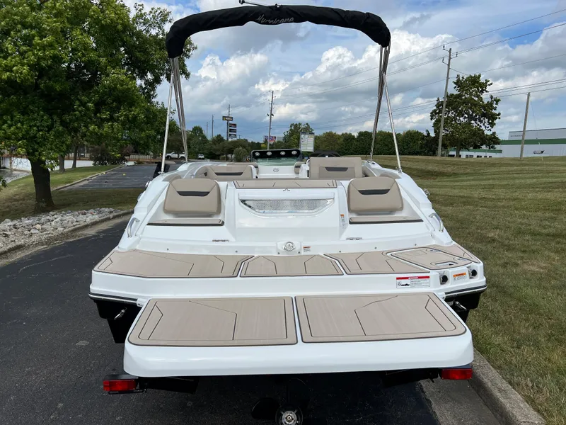 Slide: The Image of 2024 Hurricane SunDeck Sport 205 IO boat, rear view, parked on a paved road. - 4