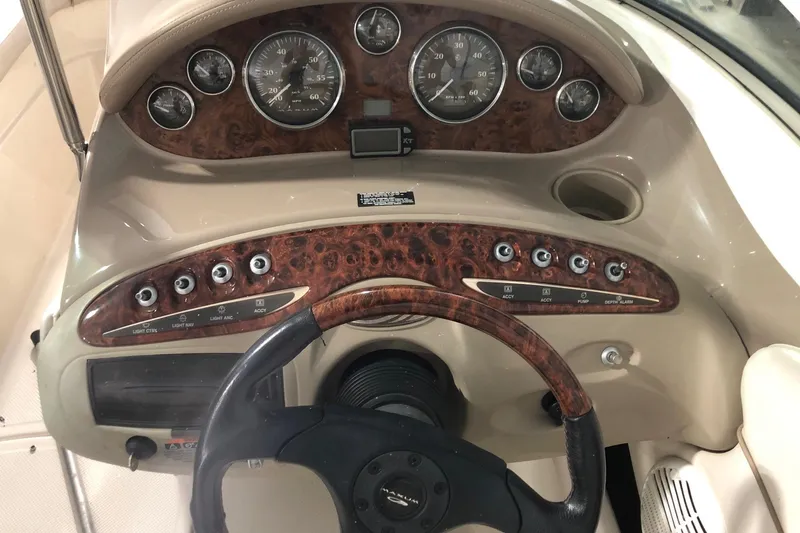 Slide: The Image of 2002 Maxum 1900 SR boat dashboard with wood grain finish and steering wheel. - 9
