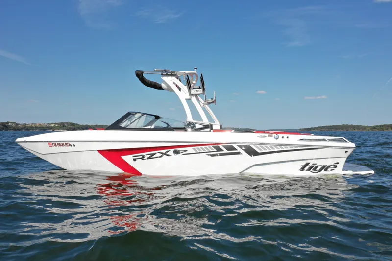 Slide: The Image of 2021 Tigé 22RZX boat on open water under clear blue sky. - 0