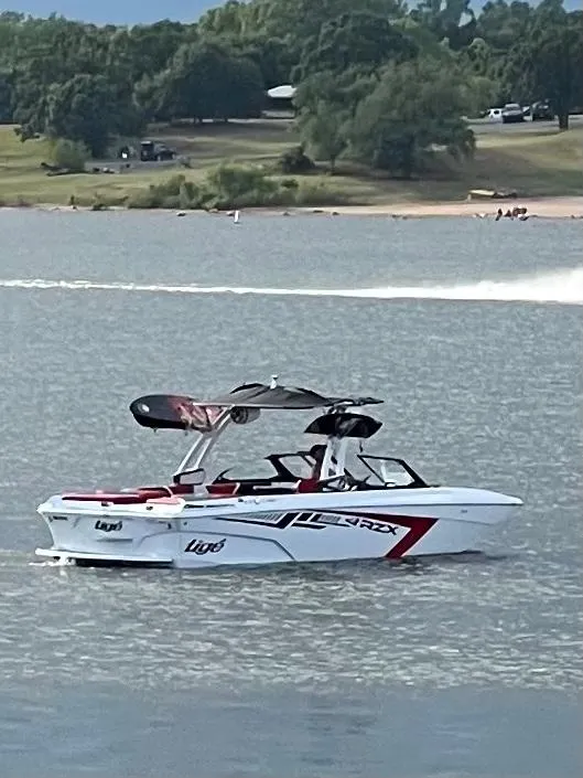 Slide: The Image of 2021 Tigé 22RZX boat on a lake with a scenic background. - 12