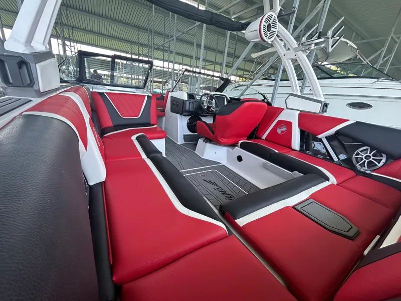Slide: The Image of 2021 Tigé 22RZX boat interior with red and black seating, modern dashboard, and sound system. - 16