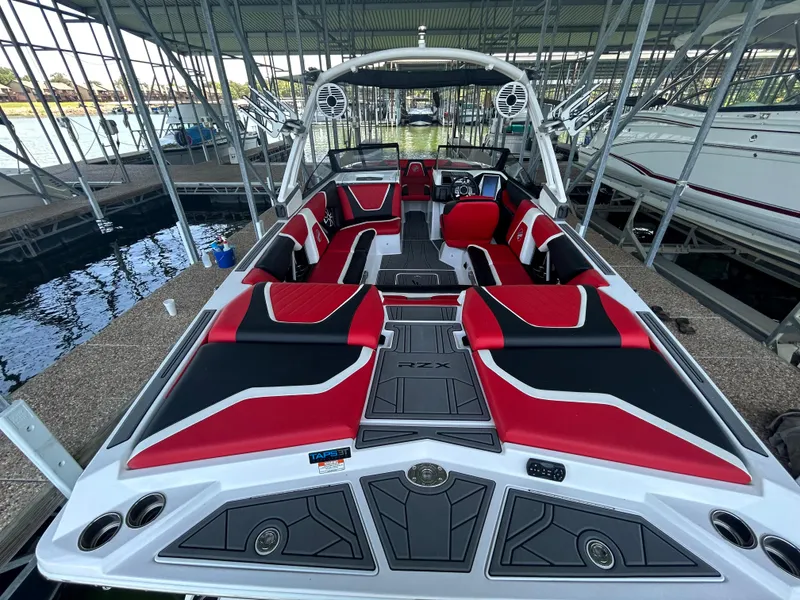 Slide: The Image of 2021 Tigé 22RZX boat with red and black interior docked in a marina. - 17