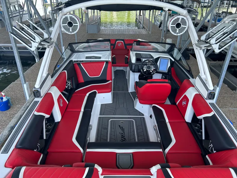 Slide: The Image of 2021 Tigé 22RZX boat with red and black interior, docked at marina. - 19