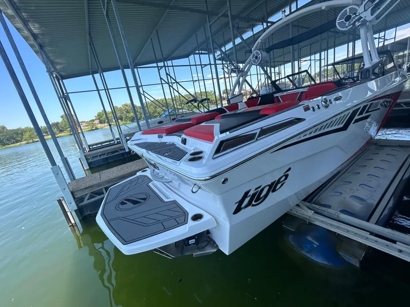 Slide: The Image of 2021 Tigé 22RZX boat docked in a covered marina. - 22