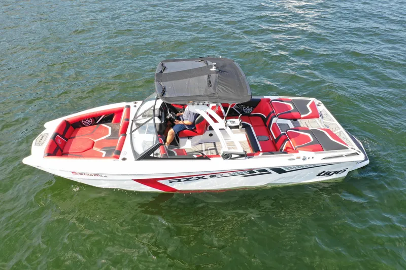Slide: The Image of 2021 Tigé 22RZX boat on water, red and white design, top view. - 3