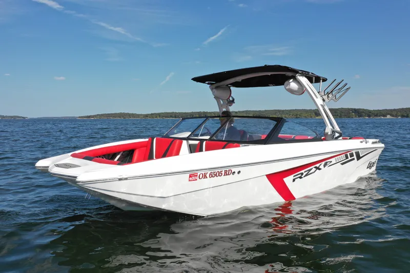 Slide: The Image of 2021 Tigé 22RZX boat on a lake with red and white design. - 6