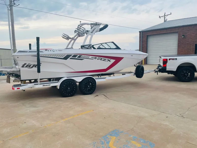 Slide: The Image of 2021 Tigé 22RZX boat on trailer, hitched to a white truck. - 8