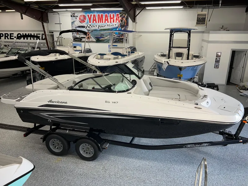 Slide: The Image of 2024 Hurricane SunDeck 187 IO boat displayed in showroom with Yamaha banner. - 0