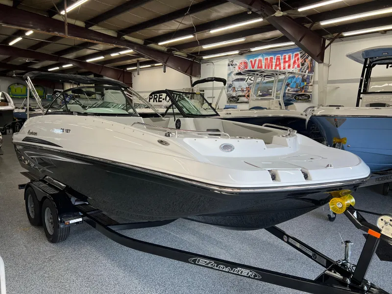 Slide: The Image of 2024 Hurricane SunDeck 187 IO boat on trailer in showroom, featuring sleek design and modern amenities. - 1