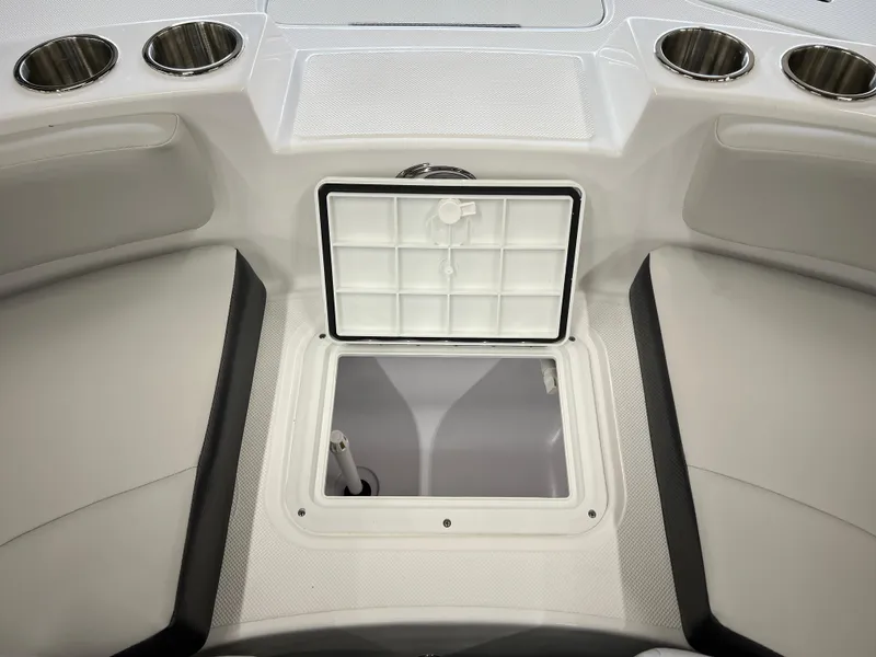 Slide: The Image of 2024 Hurricane SunDeck 187 IO boat interior with open storage compartment and cup holders. - 10