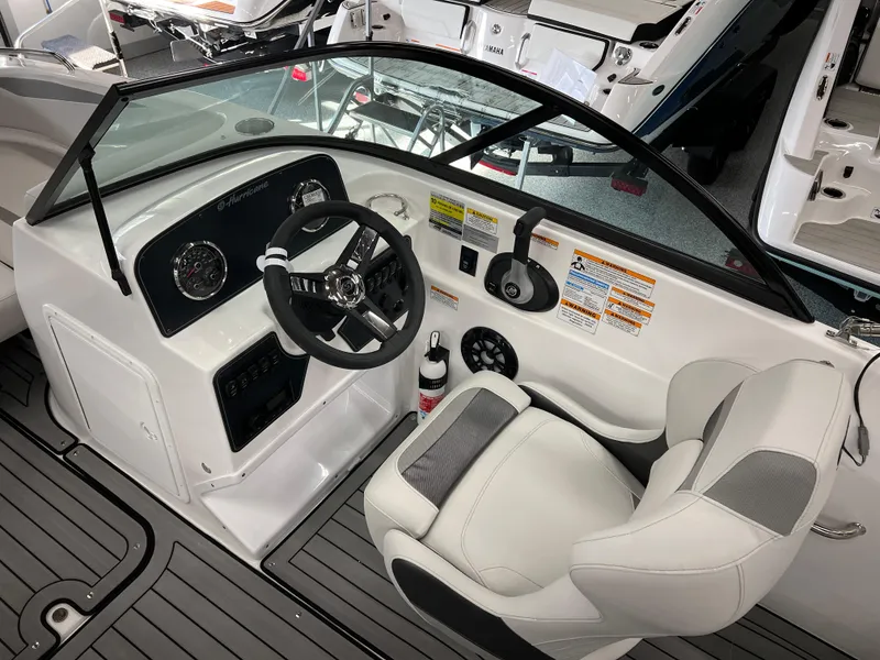 Slide: The Image of 2024 Hurricane SunDeck 187 IO boat interior with steering wheel and captain's seat. - 7