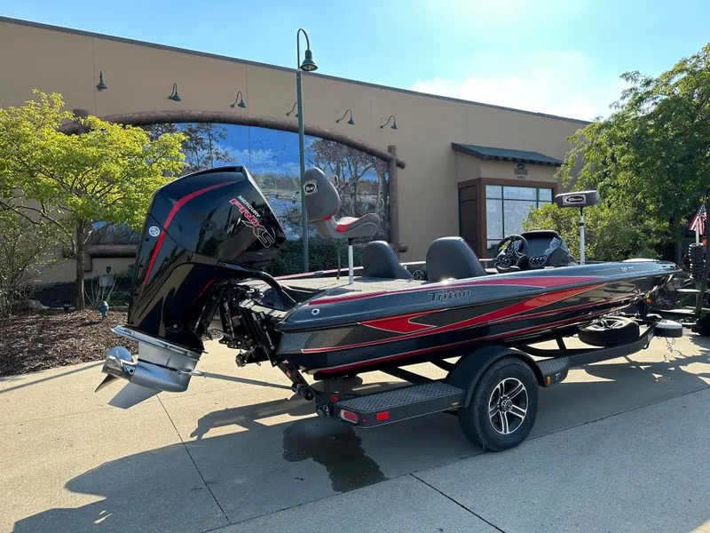 Slide: The Image of 2024 Triton 18 TrX bass boat parked outside a building. - 1