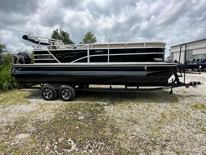 Slide: The Image of 2024 Ranger Reata 223C pontoon boat on a trailer under a cloudy sky. - 23