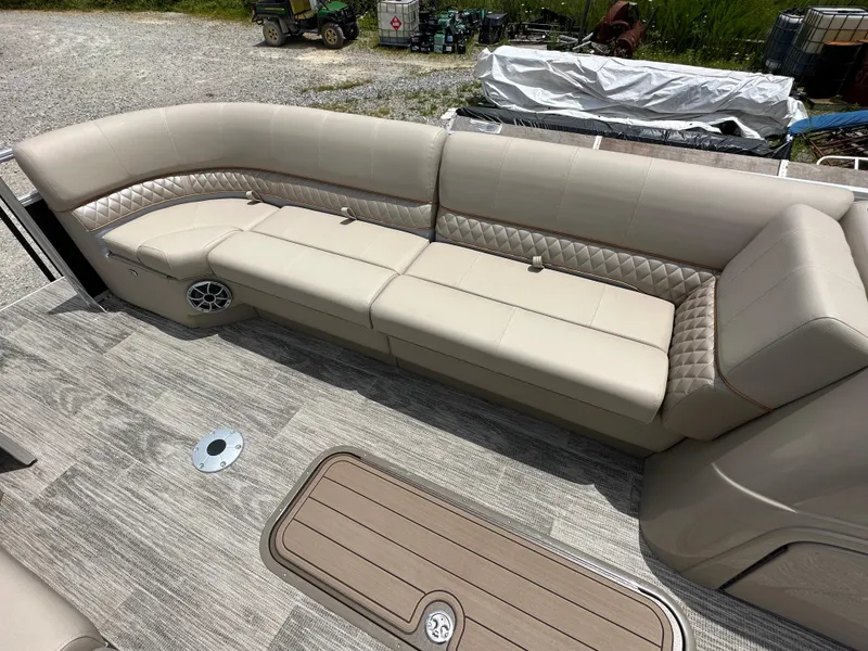 Slide: The Image of 2024 Ranger Reata 223C boat interior with beige seating and wood flooring. - 6