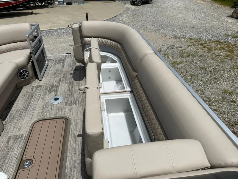 Slide: The Image of 2024 Ranger Reata 223C pontoon boat interior with beige seating and storage compartments. - 7