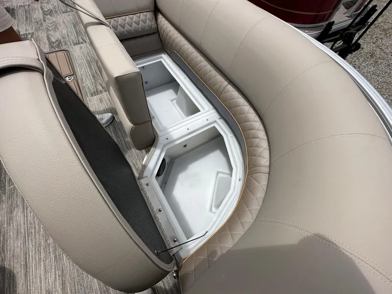 Slide: The Image of 2024 Ranger Reata 223C boat with open storage compartment and beige seating. - 8