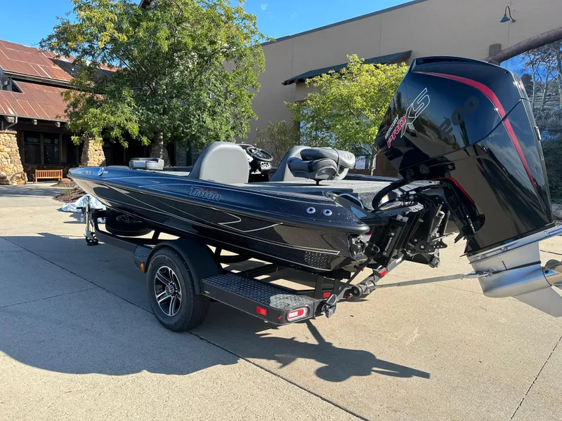 Slide: The Image of 2024 Triton 18 TrX boat on trailer, parked outdoors, sunny day. - 2
