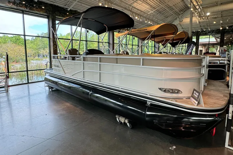 Slide: The Image of 2024 Ranger Reata 223C pontoon boat displayed indoors with canopy and sleek design. - 1