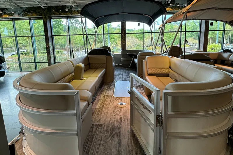 Slide: The Image of 2024 Ranger Reata 223C pontoon boat interior with beige seating and canopy. - 4