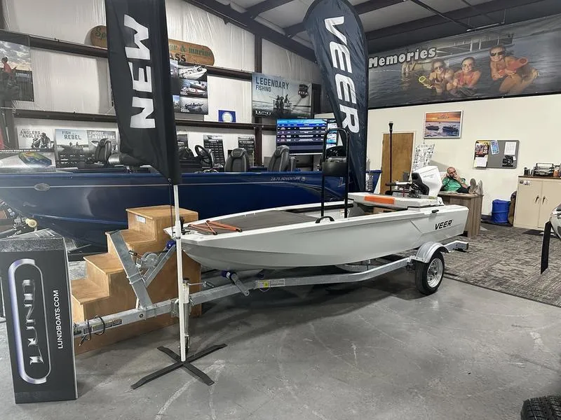 The Image of 2023 Veer V13 boat on display in showroom with promotional banners. - 1