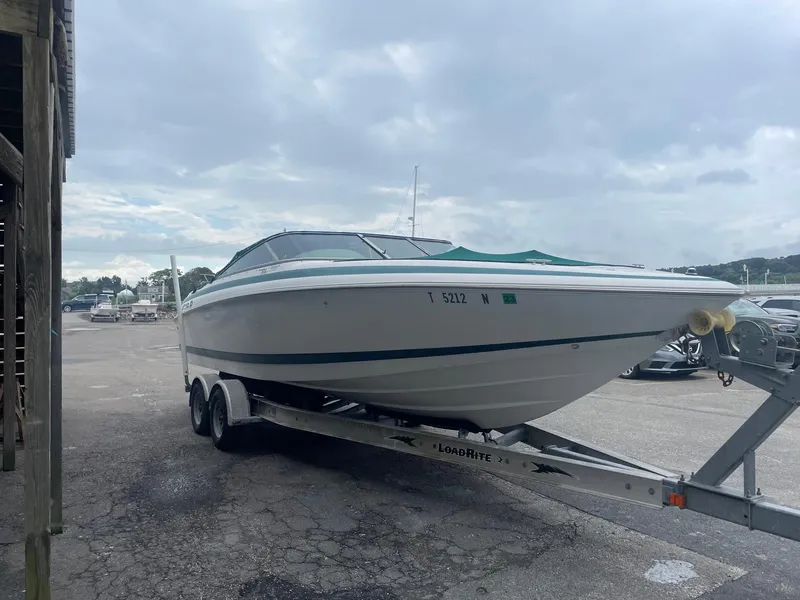 Slide: The Image of 1998 Cobalt 252 boat on a trailer in a parking lot. - 10
