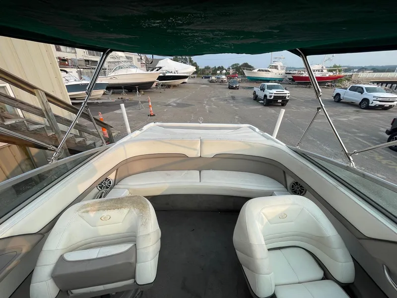 Slide: The Image of 1998 Cobalt 252 boat interior with white seating at a marina. - 13