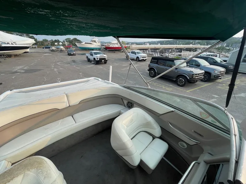 Slide: The Image of 1998 Cobalt 252 boat interior with white leather seats at a marina. - 14