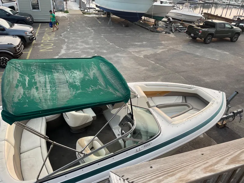 Slide: The Image of 1998 Cobalt 252 boat with green canopy at marina parking lot. - 2