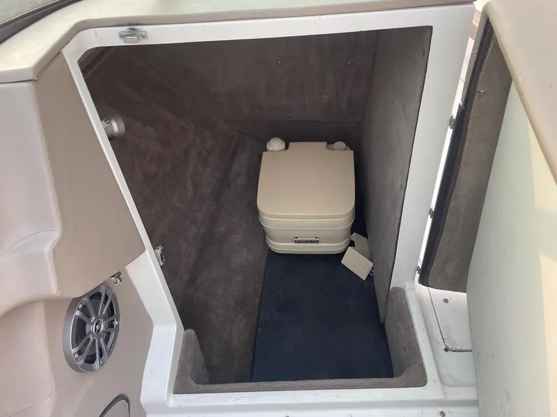 Slide: The Image of 1998 Cobalt 252 boat interior storage compartment with portable toilet. - 21