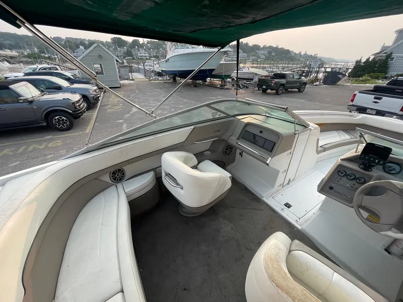 Slide: The Image of 1998 Cobalt 252 boat interior with seating and dashboard, parked at a marina. - 25