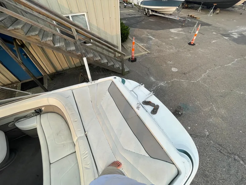 Slide: The Image of 1998 Cobalt 252 boat interior with beige seating at a marina. - 27