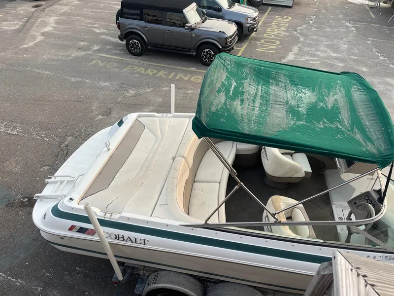 Slide: The Image of 1998 Cobalt 252 boat with green canopy in parking lot. - 3