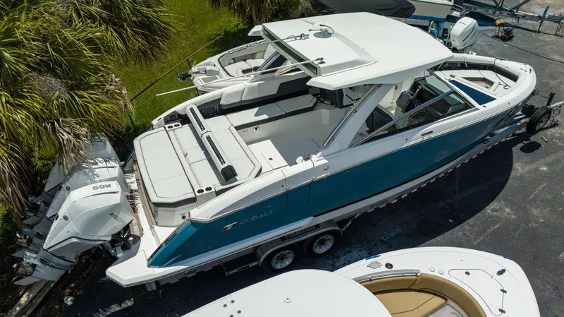 Slide: The Image of 2023 Cobalt R33 boat on trailer, parked near palm trees. - 17