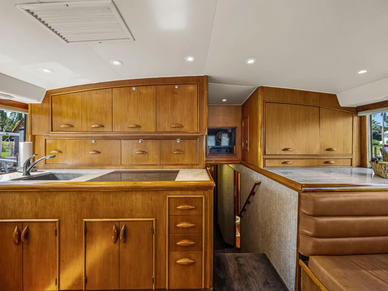 Slide: The Image of 1990 Buddy Davis 61 Convertible yacht interior with wooden cabinetry and modern amenities. - 11