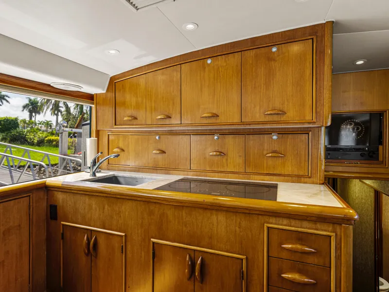 Slide: The Image of 1990 Buddy Davis 61 Convertible yacht kitchen with wooden cabinets and sink. - 12