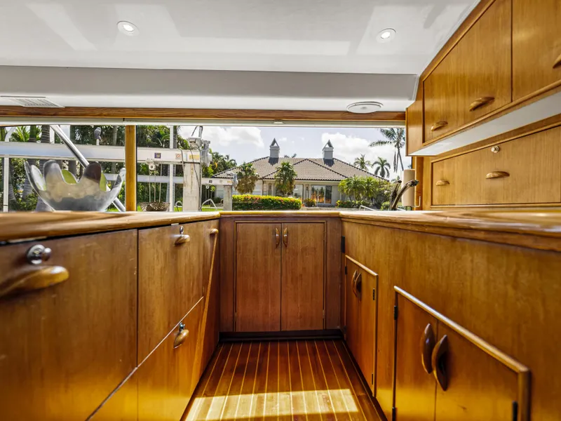 Slide: The Image of Interior of 1990 Buddy Davis 61 Convertible yacht with wooden cabinetry and scenic window view. - 13