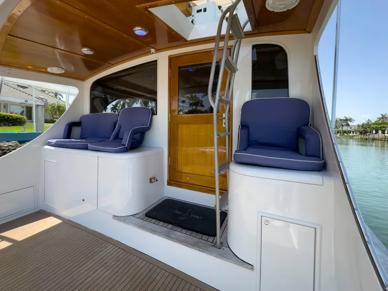 Slide: The Image of 1990 Buddy Davis 61 Convertible yacht with blue cushioned seating and wooden door. - 31