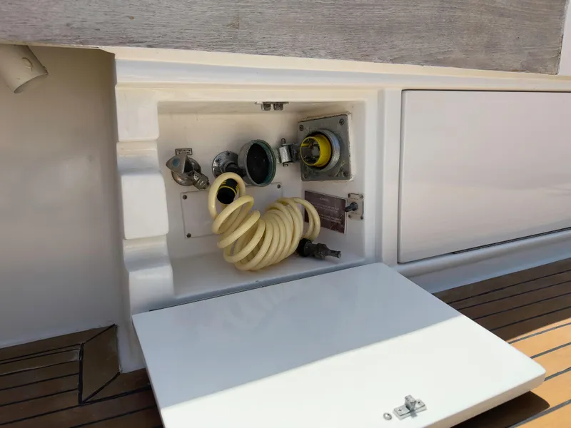 Slide: The Image of 1990 Buddy Davis 61 Convertible yacht utility compartment with coiled hose and connectors. - 33
