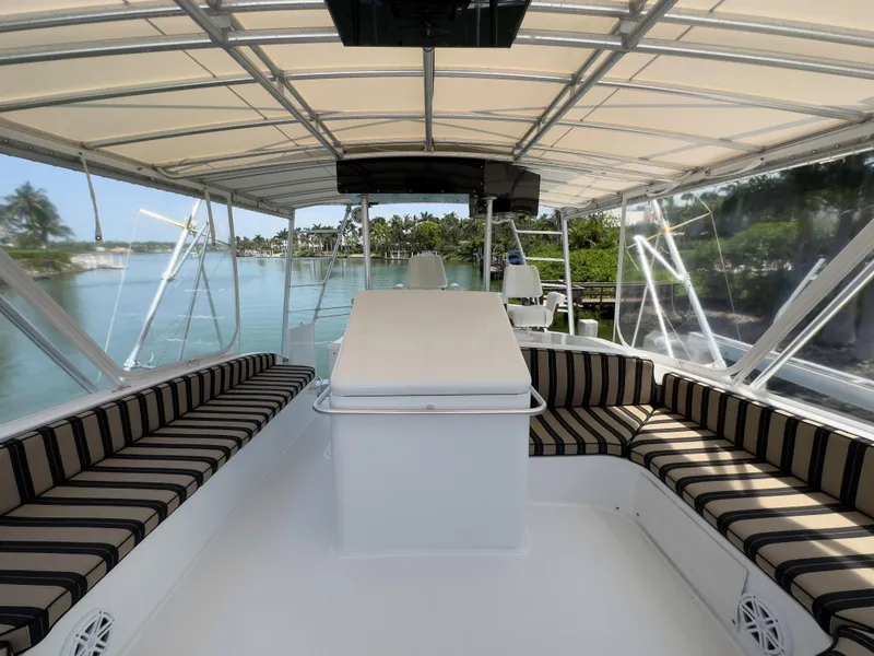 Slide: The Image of 1990 Buddy Davis 61 Convertible boat interior with striped seating and canopy. - 43