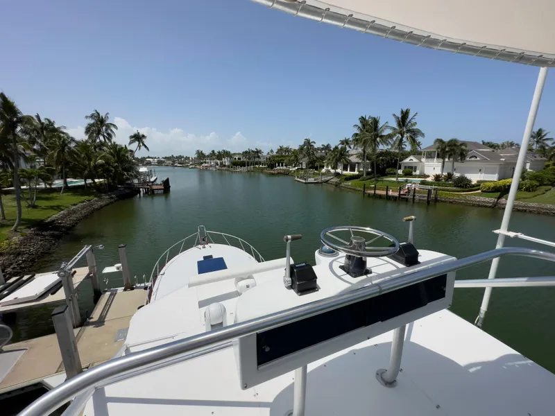 Slide: The Image of View from the helm of a 1990 Buddy Davis 61 Convertible yacht in a tropical marina. - 44