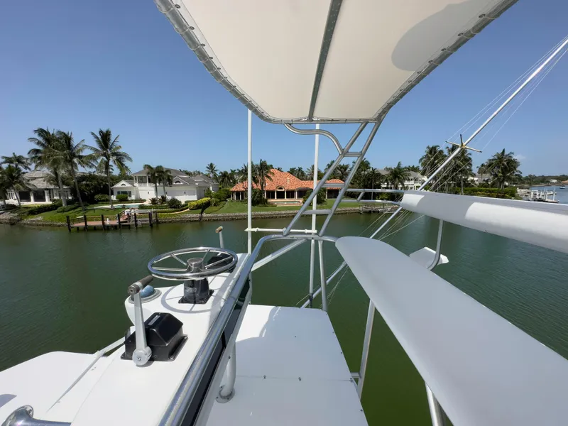 Slide: The Image of View from the flybridge of a 1990 Buddy Davis 61 Convertible yacht, overlooking a serene waterfront. - 45