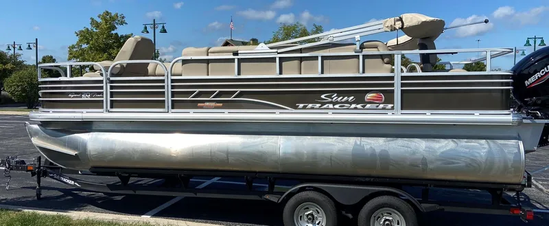 Slide: The Image of 2023 Sun Tracker SportFish 20 DLX pontoon boat on trailer in parking lot. - 2