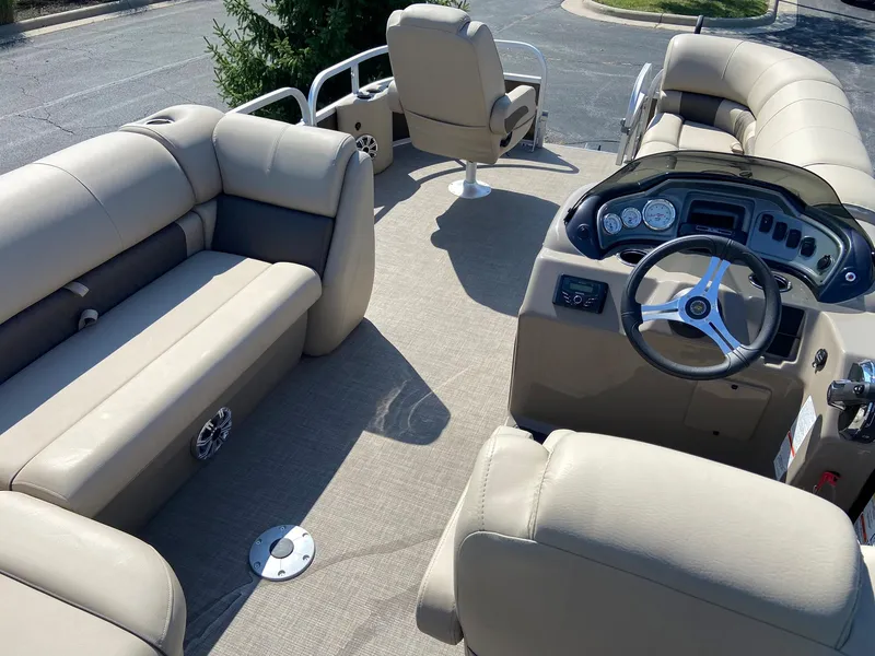 Slide: The Image of 2023 Sun Tracker SportFish 20 DLX pontoon boat interior with beige seating and steering console. - 3