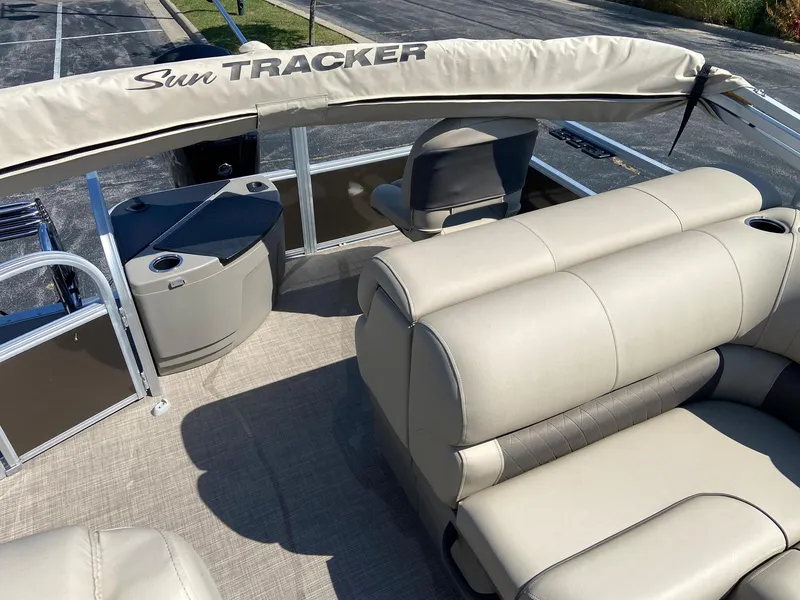 Slide: The Image of 2023 Sun Tracker SportFish 20 DLX pontoon boat interior with beige seating and canopy. - 4
