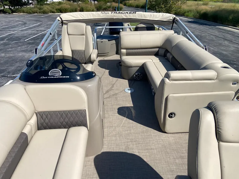 Slide: The Image of 2023 Sun Tracker SportFish 20 DLX pontoon boat interior with beige seating and helm. - 5