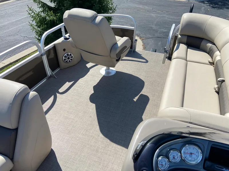 Slide: The Image of 2023 Sun Tracker SportFish 20 DLX pontoon boat interior with beige seating and control panel. - 6