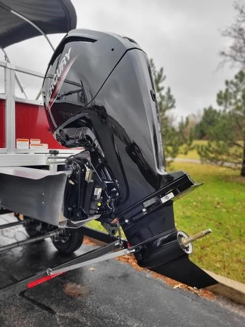 Slide: The Image of 2024 Ranger Reata 200F boat with Mercury outboard motor, parked outdoors. - 2